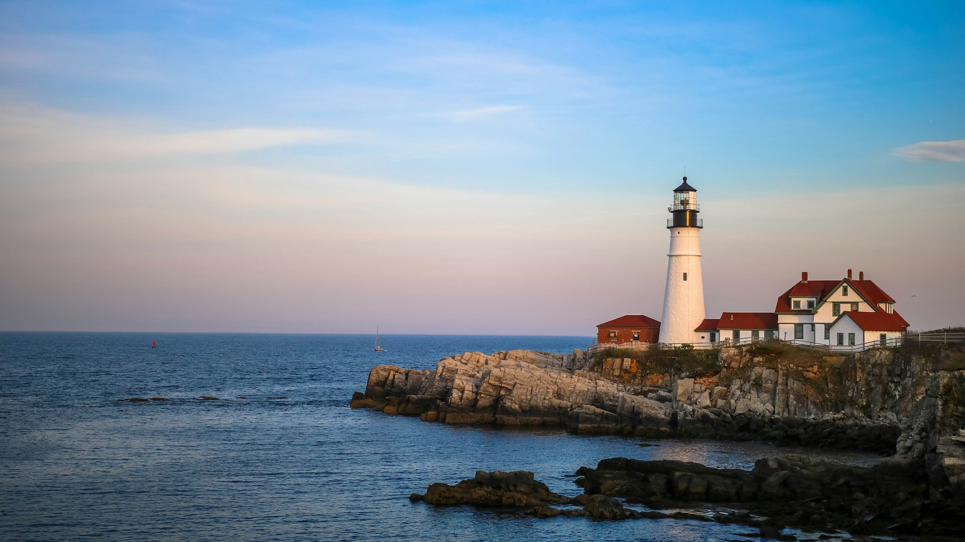 Lighthouse on a rocky coastline at dusk